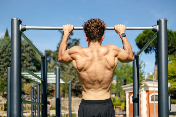 Strong young sportsman doing calisthenics