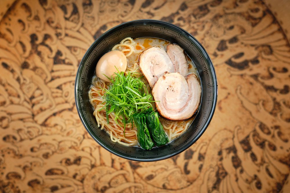 Bowl of traditional noddle dish with pork and nori in Asian restaurant