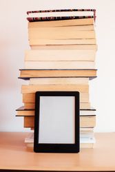 Vintage books next to an e-Book