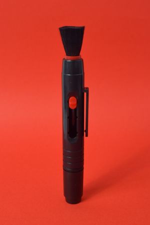 Dust remover for camera lens on red background