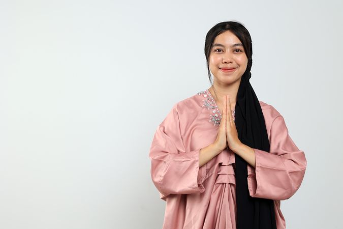 Young Asian Female Posing Hand Greeting for Eid Mubarak Celebration Concept.