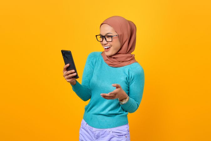 Smiling Muslim woman taking video call on her phone