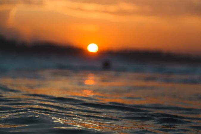 Water surface and sky with sun at sunset