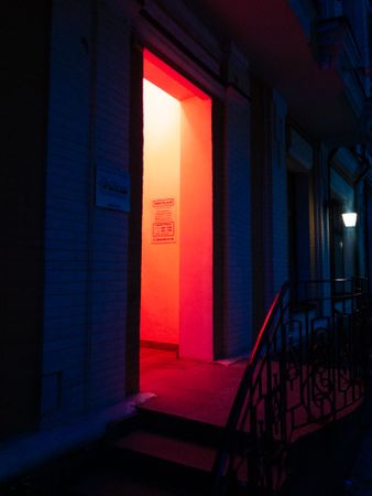 Open door of red lit room at night