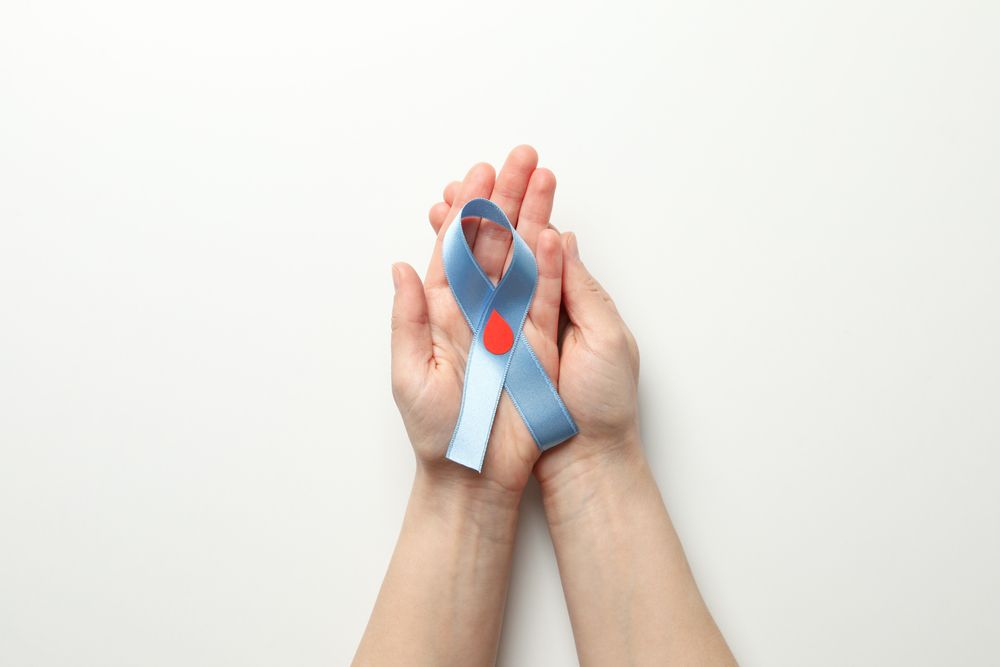 Female hands hold diabetes awareness ribbon on blank background