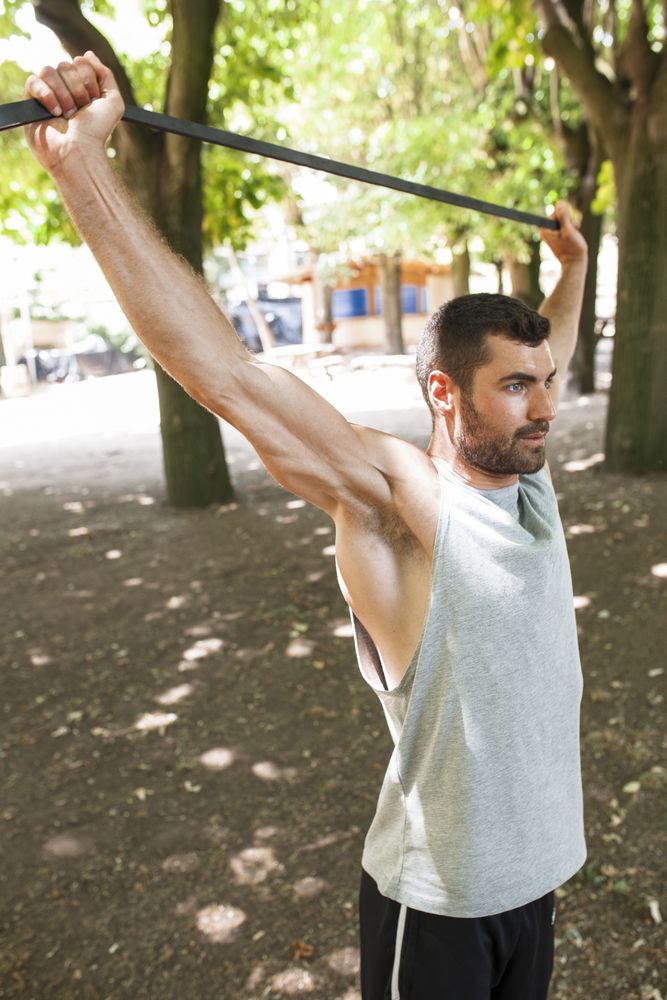 Sportsman stretching arms in park