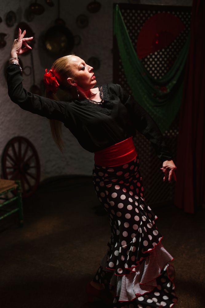 Woman dancer in flamenco costume standing in dance posture