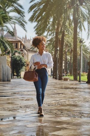 Stylish Black woman walking on street