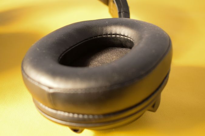 Single headphone ear cushion on yellow background
