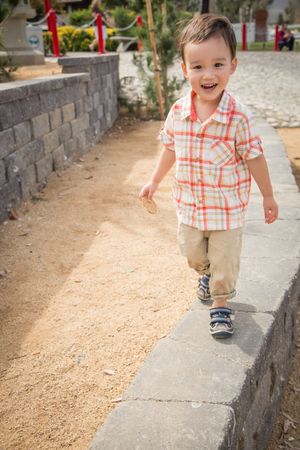 Young Biracial Boy Walking at the Park.