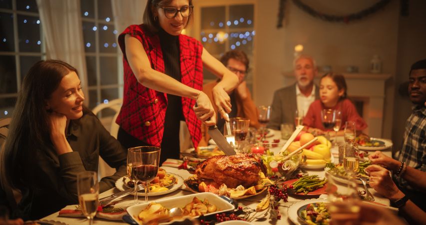 Happy Guests Sitting at a Dining Table with Tasty Meals and Festive Decorations.