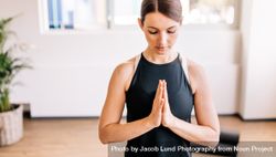 Young woman in namaste yoga pose 48Bglq