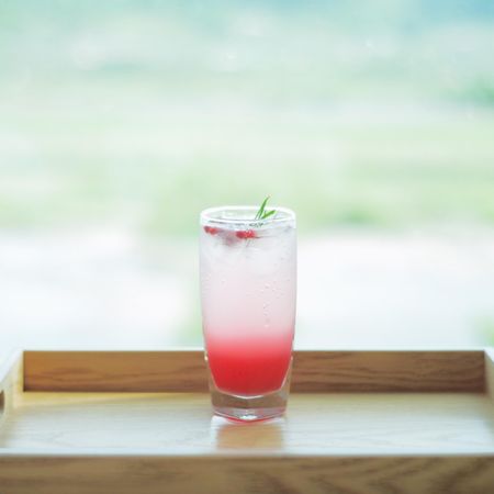 Alcoholic cocktail on a wooden table beside window