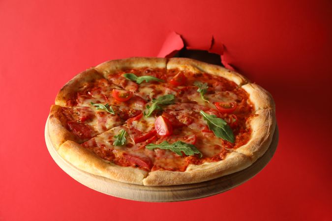 Hand hold box with tasty pizza on red background