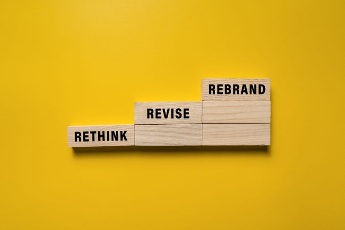 rethink revise and rebrand words on wooden blocks isolated on yellow background
