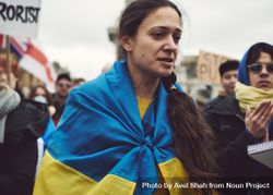 London, England, United Kingdom - March 5 2022: Sad woman draped in Ukrainian flag bGOAeb