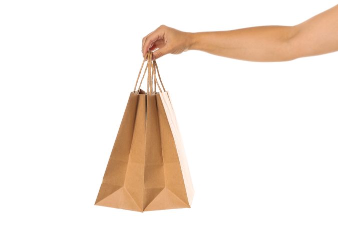 Female hand hold paper bags isolated on blank background