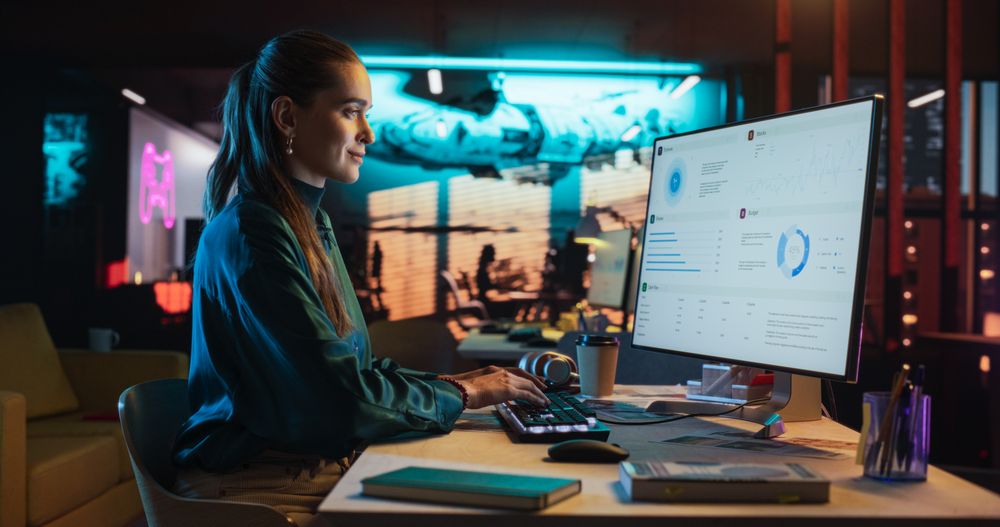 Female Talented Digital Marketing Specialist Working on Computer at Office in the Evening.