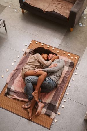 Multiethnic couple kissing on floor