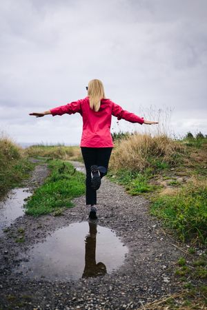 Cheerful woman enjoying countryside landscape stretching hands