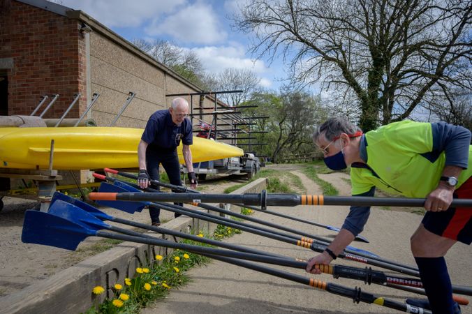 Men laying out oars for rowing