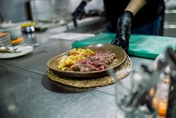 Crop person with delicious potato chip and meat dish