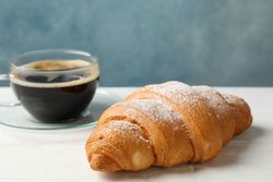 Croissants and cup of coffee in blue room