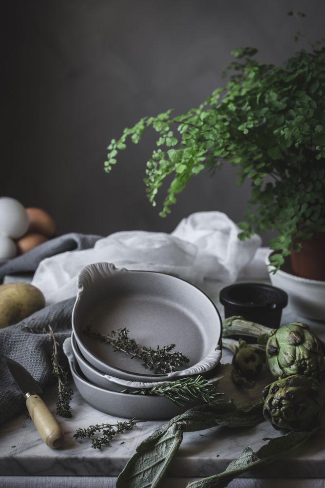 Eggs and different herbs in bowls placed on rustic table