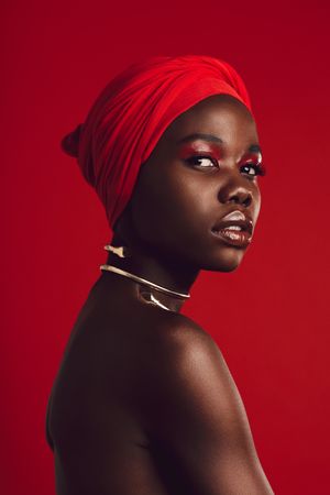 Stylish woman with red turban in studio