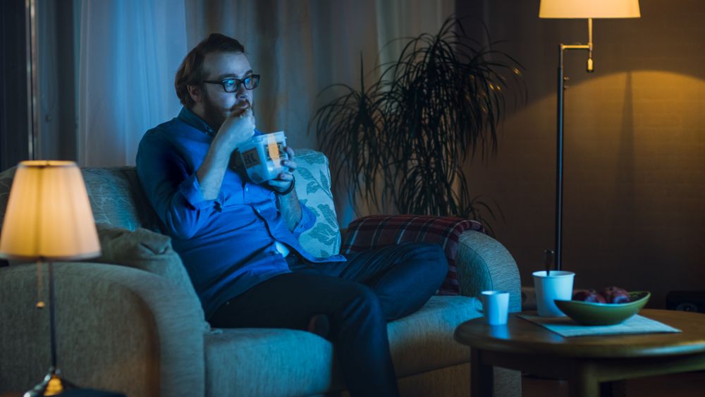 In the Evening Man Sitting on a Couch In His Living Room.