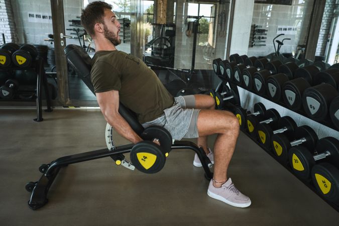 Strong man exercising with dumbbells in gym