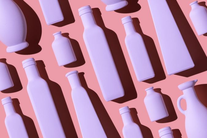 Light pink painted glass bottles on pink background