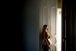 Pregnant woman near open door