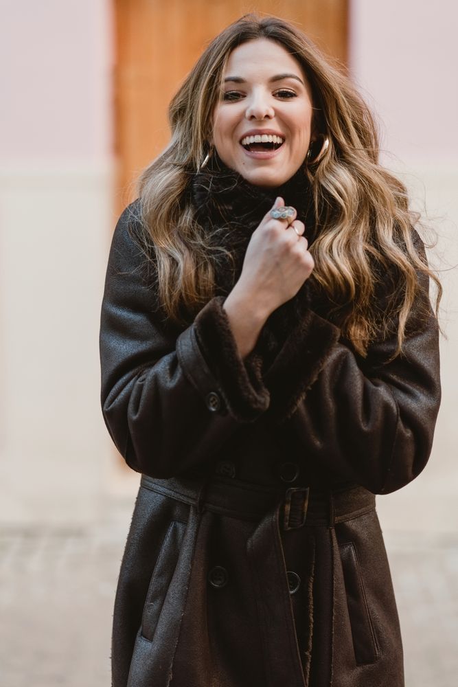 Stylish woman standing near brown door