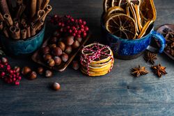 Table of fragrant Christmas items like orange slices, nuts and spices