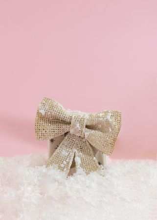Wrapped present on pink background with golden ribbon