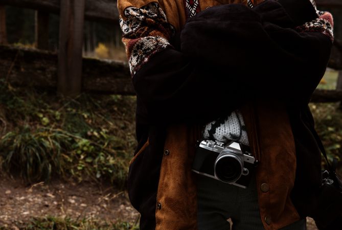 Woman with camera standing near church in mountains