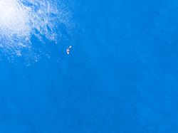 Aerial view of friends having fun on a stand up paddle board on their travel.