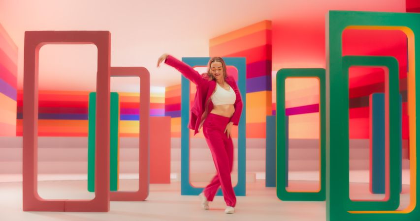 Stylish Professional Female Dancer Performing a Modern Dance Routine in Front of Big Led Wall Screen with Colorful Striped Background During a Virtual Production in Studio Environment