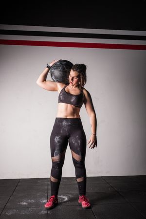 Woman lifting medicine ball in gym