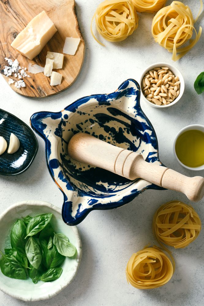 Pestle and mortar with ingredients for pesto sauce