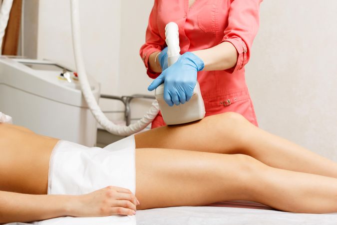Female having hair removed on upper thigh with laser treatment in medspa