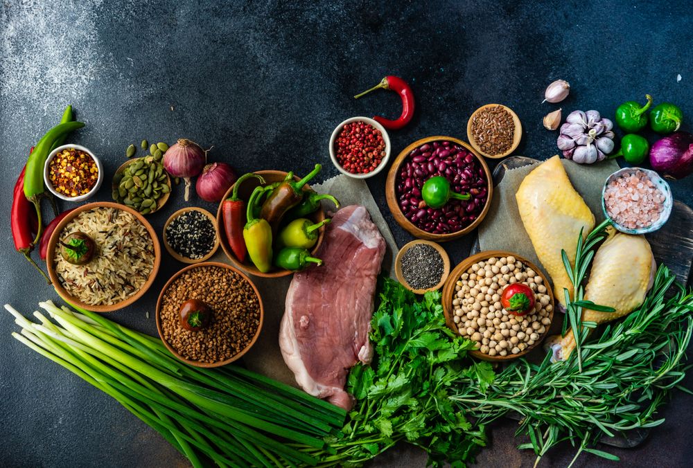 Dark kitchen counter with grains, beans and aromatics for pork and turkey dinner