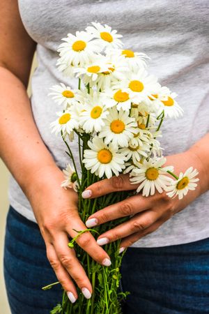Woman holding bunch of daisy flowers