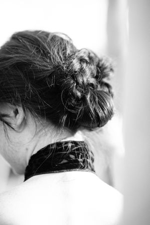 Back side view of woman’s loose hair style bun and back of her neck