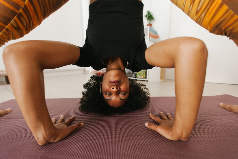 Woman with closed eyes standing with hand down on mat