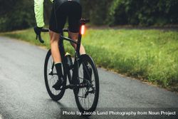 Male cyclist practising on a wet road 0PjMEO