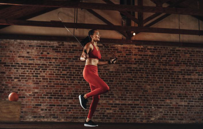 Healthy woman exercising with skipping rope at fitness studio