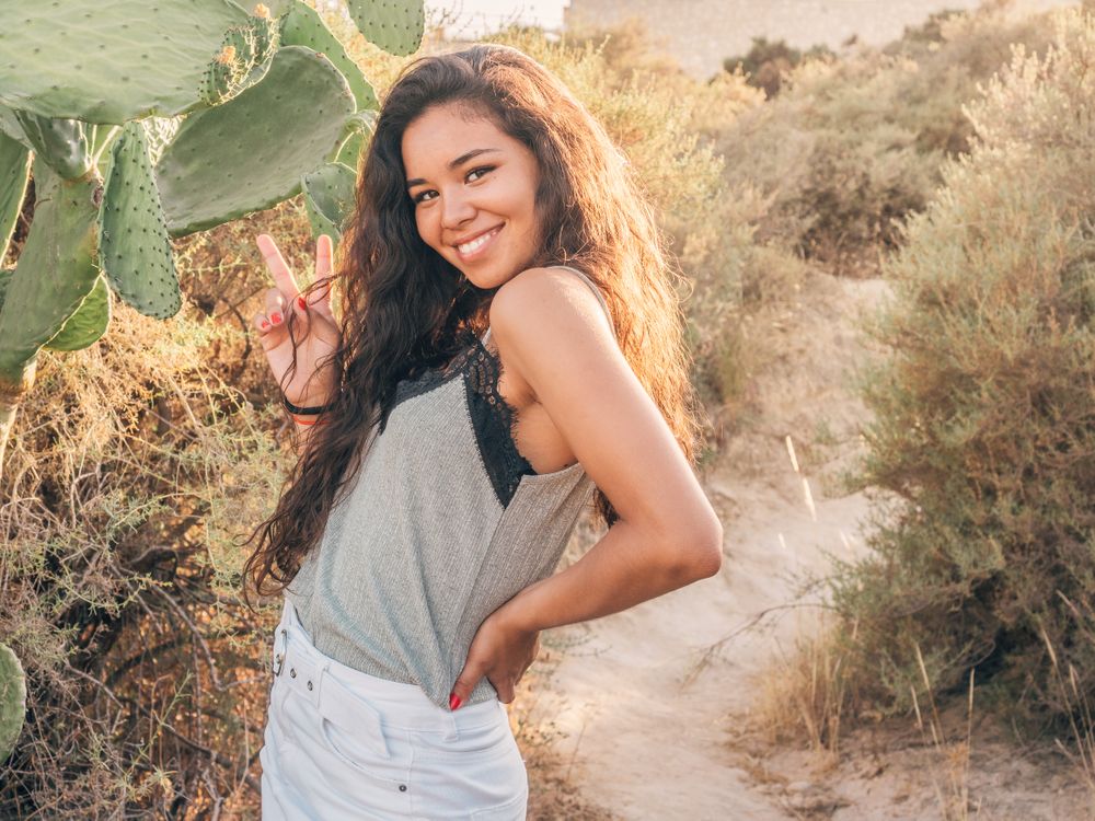 Playful trendy young woman in deserted countryside