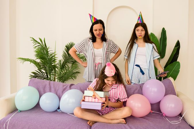 Mother and daughters examining birthday gift